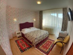 a bedroom with a bed and two rugs at Casa Ana in Sinaia
