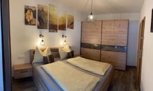 een kleine slaapkamer met een bed en een kast bij NeuhausLiving in Aschau