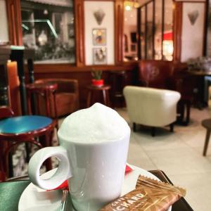 a white coffee cup sitting on a table in a restaurant at Hotel La Regence in Villefranche-sur-Mer
