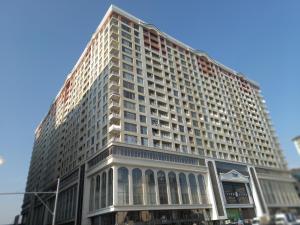 un grand bâtiment blanc au coin d'une rue dans l'établissement Park Azure, à Baku