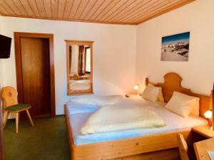 a bedroom with two beds and a mirror at Alpenhof Schwaiger - Hotel Garni in Mühlbach am Hochkönig