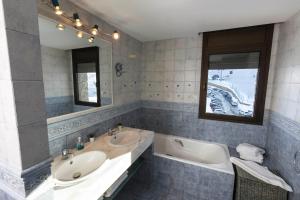 a bathroom with two sinks and a tub and a mirror at Superbe appartement 170m2 pied des pistes de ski. in Pas de la Casa +15 photos