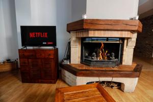 a fireplace in a living room with a tv at Superbe appartement 170m2 pied des pistes de ski. in Pas de la Casa