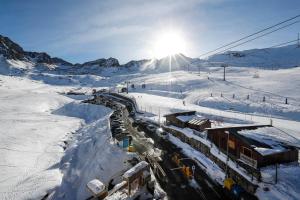 a snow covered mountain with a train on a track at Superbe appartement 170m2 pied des pistes de ski. in Pas de la Casa