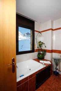a bath tub in a bathroom with a window at Superbe appartement 170m2 pied des pistes de ski. in Pas de la Casa