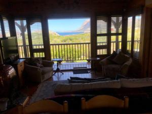 a living room with couches and a balcony with a view at Adorable 2 bedroom seaside vacation home in Kleinmond