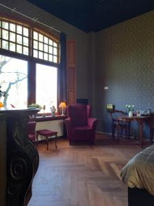 een kamer met een bed, een stoel en een raam bij B&B Villa de Beuk in Stadskanaal