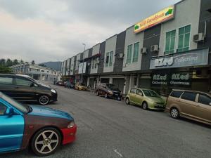 a street with cars parked in front of a building at Penginapan The CityScape - Cukup Rehat & Tidur Lena Hingga Pagi in Lumut