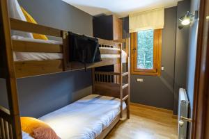 Habitación con 3 literas y TV. en TRES OSSOS Apartamento vacacional, en La Molina