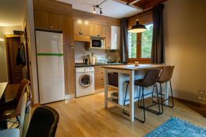 a small kitchen with a table and a refrigerator at TRES OSSOS Apartamento vacacional in La Molina