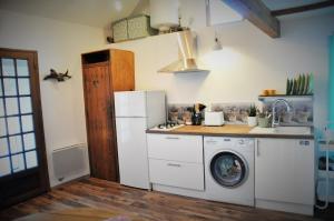 a kitchen with a washing machine and a washer at Mini Maison au Calme avec Coin Exterieur in Eygliers