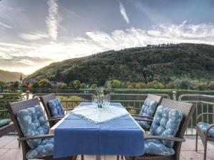 a table and chairs on a balcony with a mountain at Ferienhaus Bullay in Bullay