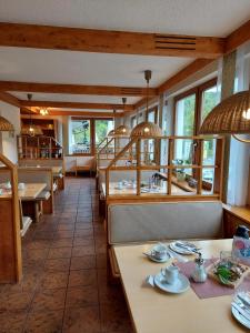 un comedor con mesas, sillas y ventanas en Hotel Landgasthof Frankenstern en Gößweinstein