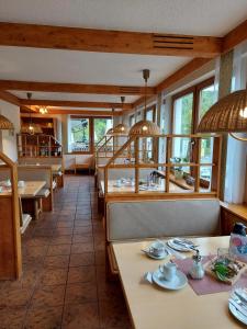 ein Esszimmer mit Tischen, Stühlen und Fenstern in der Unterkunft Hotel Landgasthof Frankenstern in Gößweinstein