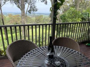 波高尔宾Villa Provincial Cypress Lakes Resort - 2 Bedrooms, 2 Private Ensuites, KING or SINGLE BEDS的桌子上有一瓶酒和两个酒杯