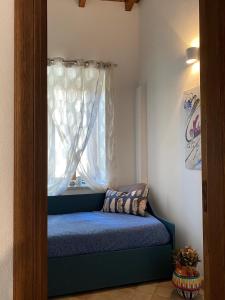 a small room with a window with a blue couch at Adamas Domus in Taormina
