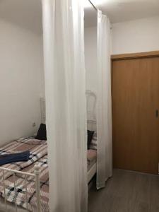 プラハにあるApartment Happy 11のベッドルーム1室(白いカーテン付きのベッド1台付)