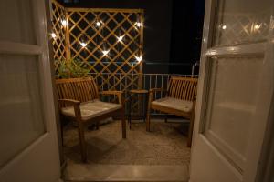 une chambre avec deux chaises et un balcon éclairé dans l'établissement Le Dimore di Freya, à Catane