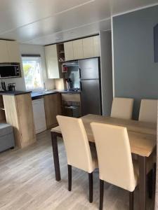 a kitchen with a wooden table and white chairs at Vue Mer in Quiberon