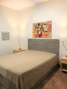 - une chambre avec un lit et une peinture murale dans l'établissement Case Montalbano, à San Vito Lo Capo