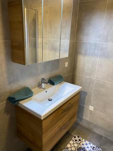 a bathroom with a white sink and a mirror at Hotel Schwarzer Adler in Pettneu am Arlberg