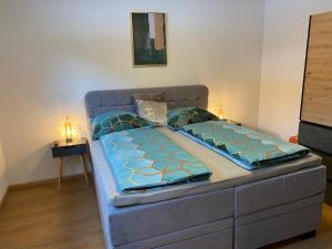 a bed in a room with a blue bed frame at Hotel Schwarzer Adler in Pettneu am Arlberg