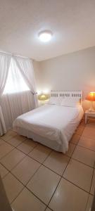 a bedroom with a white bed and a tiled floor at MARGATE BOULEVARD SPACIOUS APARTMENT in Margate