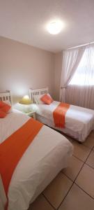 two beds in a room with a window at Margate Boulevard Beachfront Apartment in Margate