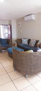 a living room with wicker chairs and couches at MARGATE BOULEVARD SPACIOUS APARTMENT in Margate