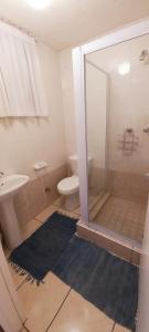 a bathroom with a shower and a toilet and a sink at Margate Boulevard Beachfront Apartment in Margate
