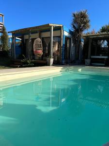 a swimming pool in front of a house at Posada de la Viuda in Punta Del Diablo