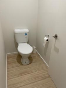 een wit toilet in een badkamer met een houten vloer bij Portland Bay Lodge, 2 Bedroom Apartments in Portland