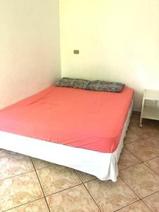 Cama pequeña en habitación con colchón rojo en Chácara Refugio das Maritacas Itu, en Itu