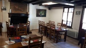 uma sala de jantar com mesas e cadeiras num restaurante em Hotel La Grotte em Sagy