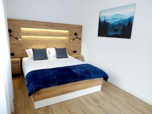 sypialnia z łóżkiem z niebieskim kocem w obiekcie Westa Apartamenty w mieście Krynica Zdrój