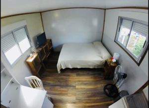 ein kleines Schlafzimmer mit einem Bett und zwei Fenstern in der Unterkunft small house in Maldonado