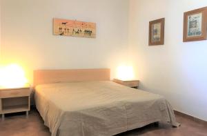 サン・ヴィート・ロ・カーポにあるCase Montalbanoのベッドルーム1室(ベッド1台、ランプ2つ、テーブル2台付)