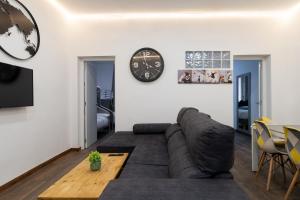 a living room with a couch and a clock on the wall at vip CERVANTES, by MONARO***** in Madrid