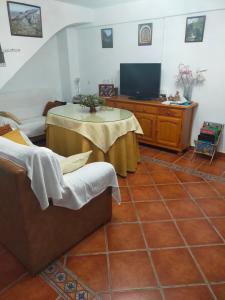 een woonkamer met een tafel en een tv bij Alojamiento Rural Los Barrosos in Coripe +11 foto's