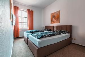 Un dormitorio con dos camas y una ventana. en Casa Mexicana, en Nienburg