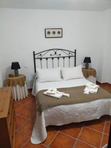 een slaapkamer met een bed met twee handdoeken erop bij Alojamiento Rural Los Barrosos in Coripe