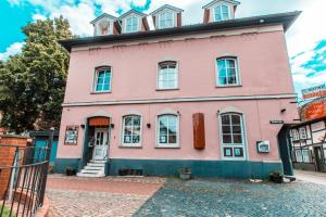 a pink house on a cobblestone street at Casa Mexicana in Nienburg