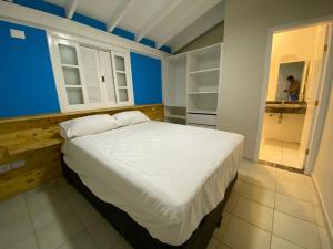 a bedroom with a large bed in a blue room at Linda casa em condomínio Sun House Maresias com piscina - 50 m da praia in Maresias +19 photos