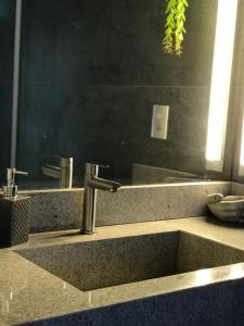 a bathroom counter with a sink and a mirror at Suíte Vista Mar Praia Estaleiro Balneário Camboriú in Balneário Camboriú +18 photos