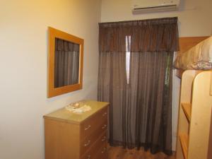 马尔萨斯卡拉Panoramic Penthouse in Marsascala which enjoys sea and country views的一间卧室配有梳妆台和带窗帘的窗户。