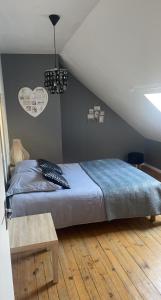 Schlafzimmer mit einem Bett mit blauer Decke in der Unterkunft Erliz in Noyon
