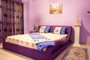 a purple bedroom with a bed in a room at Summer by the sea in Paralia Katerinis