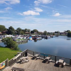 a dock with benches and boats in a marina at Lovely Static 6 Bed Caravan at Billing Aquadrome in Great Billing