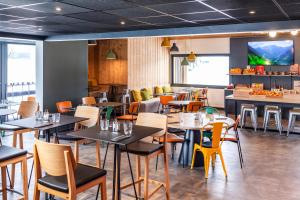 a restaurant with tables and chairs and a counter at Ibis Pontarlier in Pontarlier