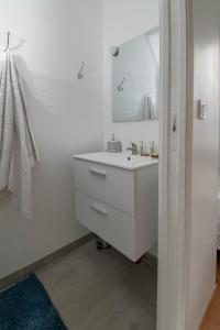 Baño blanco con lavabo y espejo en Le Progrès, en Villeurbanne